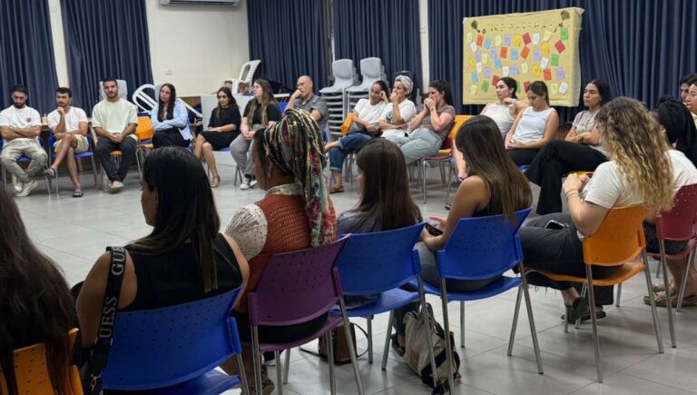 משתתפים יושבים במעגל שיח ומקיימים דיון פתוח ומונחה כחלק מפעילות הקומה הישראלית