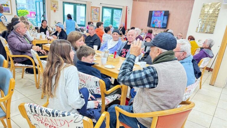 מבוגרים וילדים יושבים יחד במפגש קהילתי ומשוחחים באווירה חמה כחלק מפעילות הקומה הישראלית