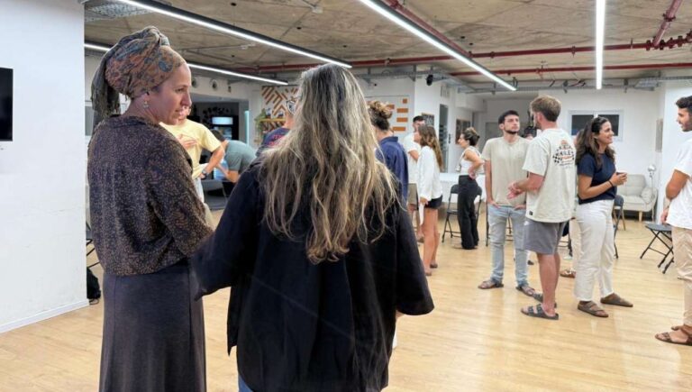משתתפים משוחחים זה עם זה באווירה פתוחה לאחר פעילות קבוצתית, כחלק ממפגש קהילתי של הקומה הישראלית