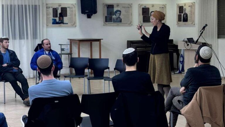מנחה עומדת ומובילה שיח פתוח עם קבוצת צעירים במפגש חינוכי־ערכי במסגרת פעילות הקומה הישראלית