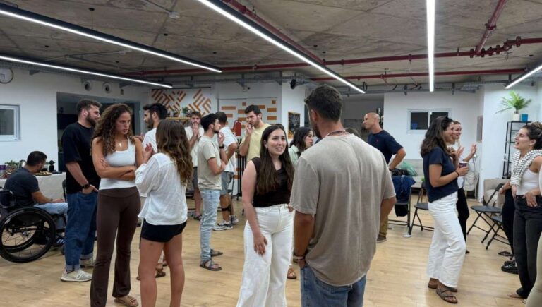צעירים משוחחים בקבוצות קטנות במרחב קהילתי פתוח, כחלק מפעילות חיבור והעמקה של הקומה הישראלית